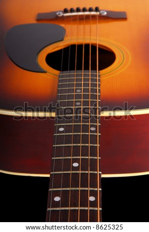 Looking down the neck of acoustic guitar with shallow focus