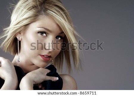 Beautiful blonde woman and fancy earrings with hair blowing