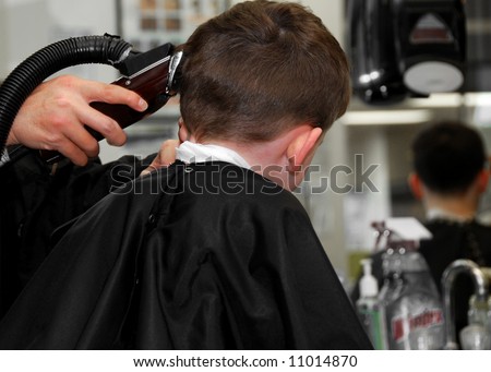 Young boy getting hair cut at barbershop