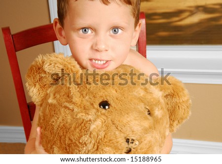 Young boy holding huge bear by window