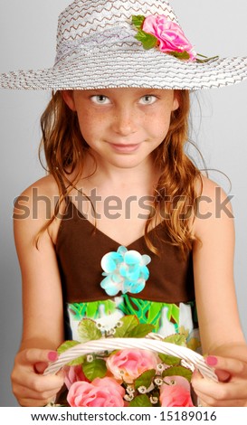 Young girl wearing pretty bonnet holding flower bouquet