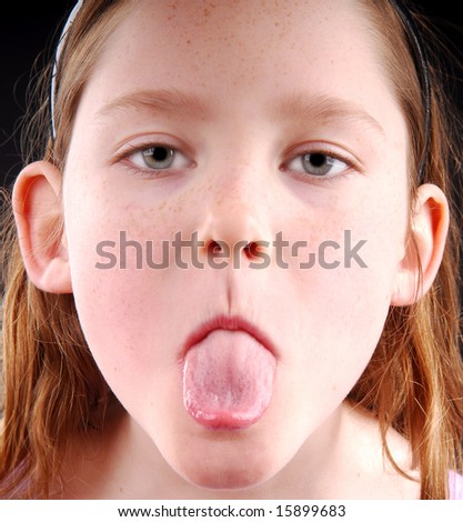 Young girl showing displeasure by sticking out tongue