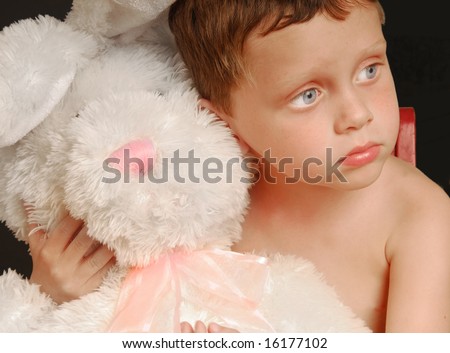 Cute young boy hugging big stuffed bunny