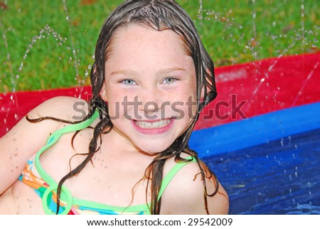 Young girl having fun outdoors during water play