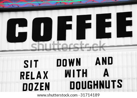 sign for coffee shop suggesting patrons eat a dozen donuts
