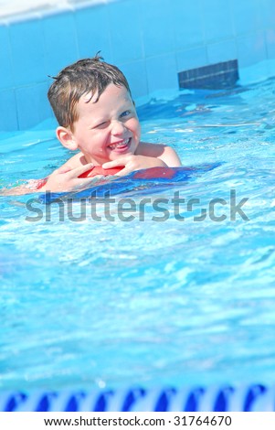 young boy having fun at swimming lesson in pool