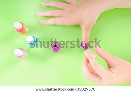Young girl putting on own purple nail polish