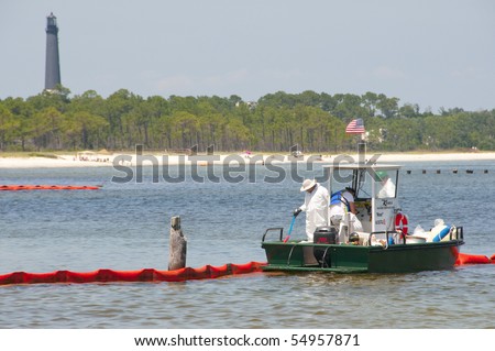 PENSACOLA - JUNE 10:  Oil spill workers clean the beach on Naval Air Station Pensacola, FL as oil washes ashore on June 10, 2010 from the BP spill.