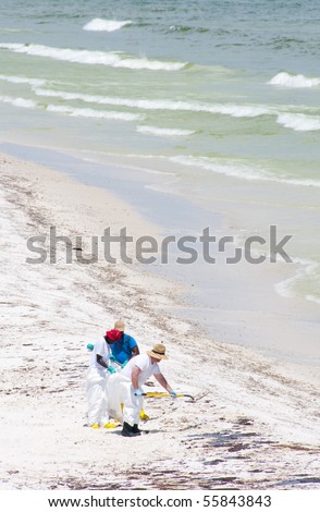PENSACOLA BEACH - JUNE 23:  BP oil workers attempt to clean oil covered sand on June 23, 2010 in Pensacola Beach, FL.