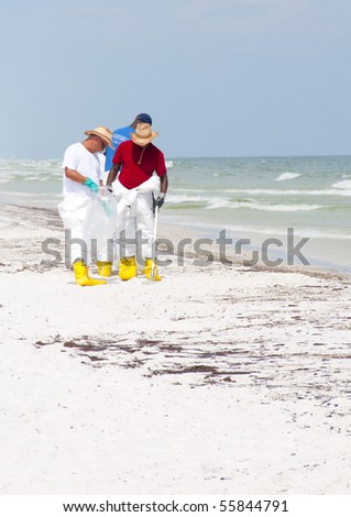 PENSACOLA BEACH - JUNE 23: BP oil workers attempt to clean the beach of oil on June 23, 2010 in Pensacola Beach, FL.