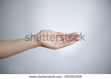 Male hand on a gray background. Empty outstretched palm. Copy space