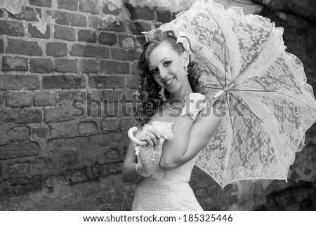 Beautiful bride in white dress with umbrella. Black and white photography