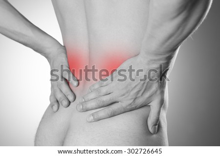 Kidney pain. Man with backache. Pain in the man\'s body on a gray background