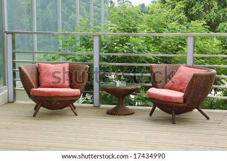 Wicker chairs on the patio in a beautiful garden.