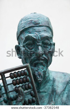 Sculptural portrait of old man with the  Qing Dynasty\'s dress and  a Chinese abacus on hand