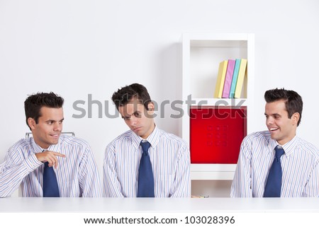 Two businessman making fun of a sad twin businessman