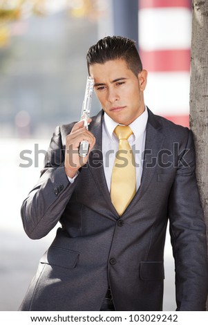 Stressed businessman with a gun pointing to his head