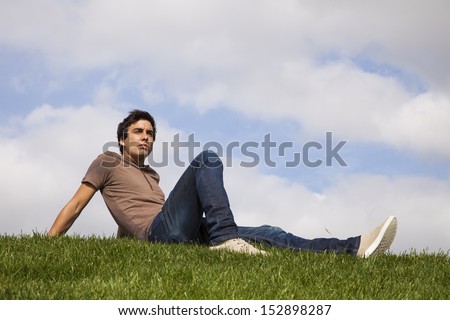 Young men sited on the grass looking away
