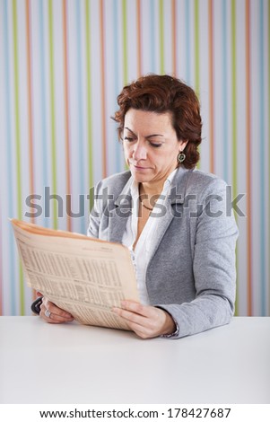 Businesswoman reading the newspaper at the office