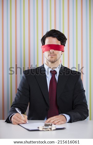 Blindfold businessman at his office signing contracts