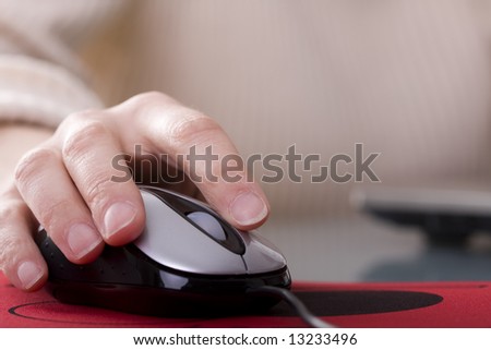 Woman hand on a mouse with copy space (selective ans soft focus)