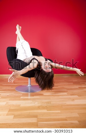young woman enjoying her new house, upside down on her couch