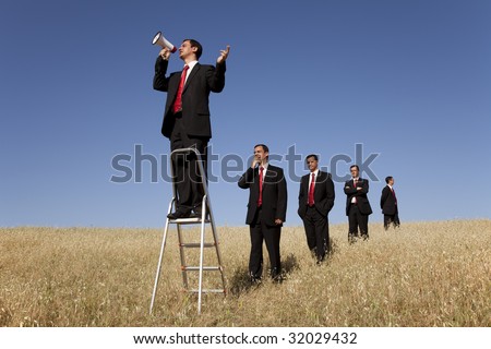 a group of businessman in the field getting in line for there time to speak