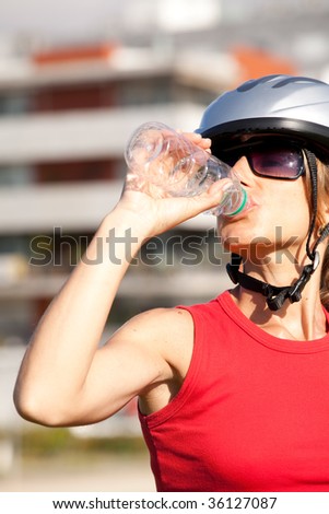 young woman drinking water after doing some bicycle exercise