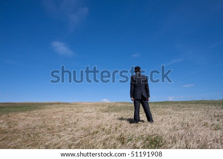 businessman standing alone at the field