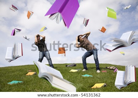Teenager students outside protecting there heads from a rain of books