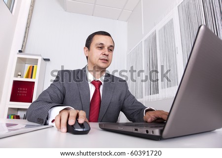 Mature businessman working at the office with his laptop