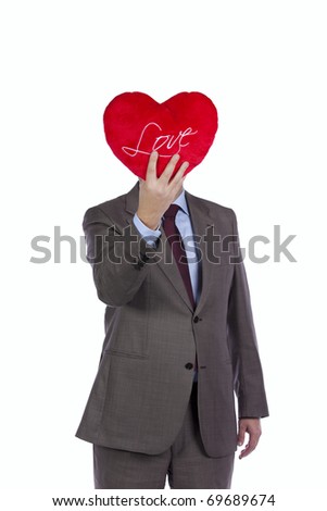 Businessman holding a red pillow with a heart shape in front of his head (isolated on white)