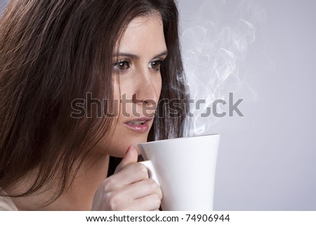 Beautiful woman portrait holding a mug with some hot drink