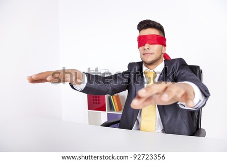 Businessman at his office with scarf covering his eyes