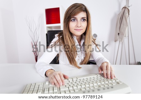 Businesswoman at her office typing at the computer keyboard
