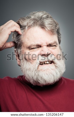 A mature man in his 50\'s scratching his head with a look of confusion.