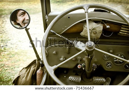 Close up of vintage jeep Willys with man face in mirror