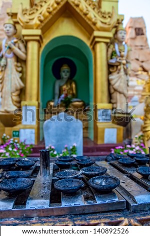 YANGON, MYANMAR - MARCH 1: Praying place with candle holders at Shwedagon Pagoda in front of Buddha altar visited by thousands prayers and tourists everyday on March 1, 2012 in Yangon, Myanmar.