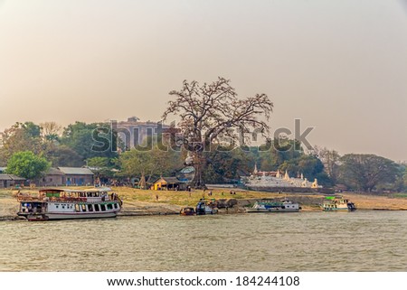 MINGUN, MYANMAR - FEBRUARY 26, 2013: People and ships in the docks of the Tourist attraction - Base of Never Completed Pagoda Pa Hto Taw Gyi