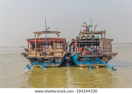MANDALAY, MYANMAR - FEBRUARY 26, 2013: People living in transport ships in harbor on the bank of the Irrawaddi river.