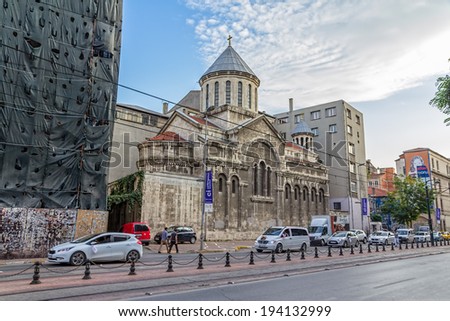 ISTANBUL, TURKEY - SEPTEMBER 28, 2013: The old Church of St Peter and St Paul surrounded by newer buildings, tram wire and road.