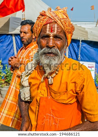 HARIDWAR, INDIA - APRIL 12, 2010: Sadhu portrait in orange clothes on the Kumbh Mela - is a mass Hindu pilgrimage of faith in Which Hindus gather to bathe in the sacred river.