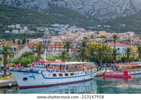 MAKARSKA, CROATIA - JULY 22, 2014: Tourist boat Voga and half-submarine vaiting for the tourists in the city harbor at summer morning.