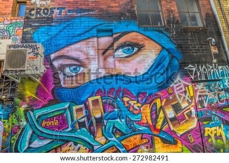 MELBOURNE, AUSTRALIA - MARCH 21, 2015: Colorful graffiti in back alley of downtown, depicts an blue eyes of a woman in a blue scarf.