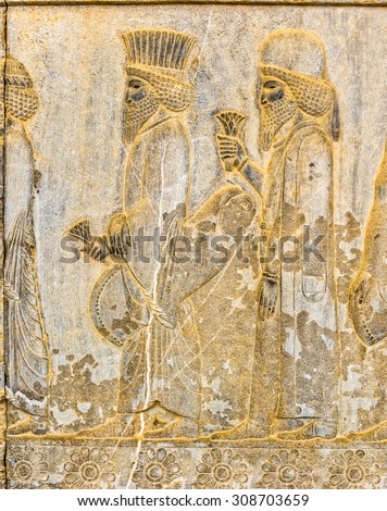 Persian noblemen on their way to the royal feast bas-relief detail on the stairway facade of the Apadana at the old city Persepolis.