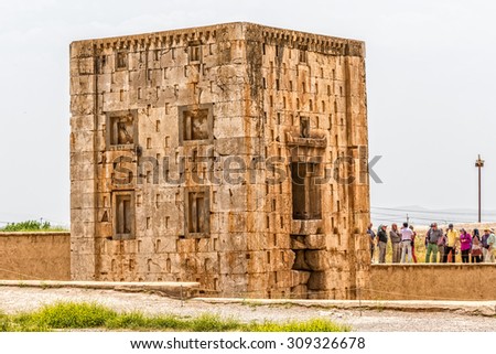 NAQSH-E RUSTAM, IRAN - MAY 3, 2015: The group of tourists with the tour guide checking out the Cube shaped construction Cube of Zoroaster, 5th century B.C.E.
