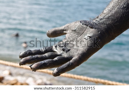 Hand covered with mud from Dead sea, Jordan. Skincare treatment. Use of high depth of field to blur the background.