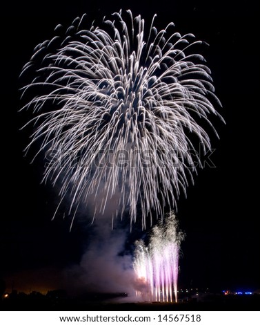 Fireworks rockets exploding against dark sky.