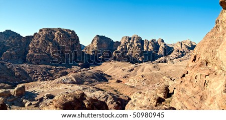Jordan Petra desert panorama with a toms in the distance and blue sky above. Roman temple in front