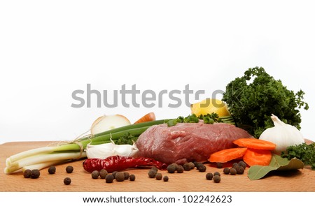 raw meat, vegetables and spices isolated on a wooden table.